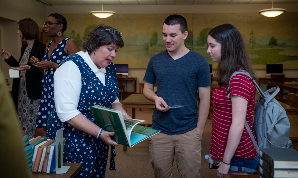 Ann Case, university archivist, speaks with students in the TUSC Reading Room